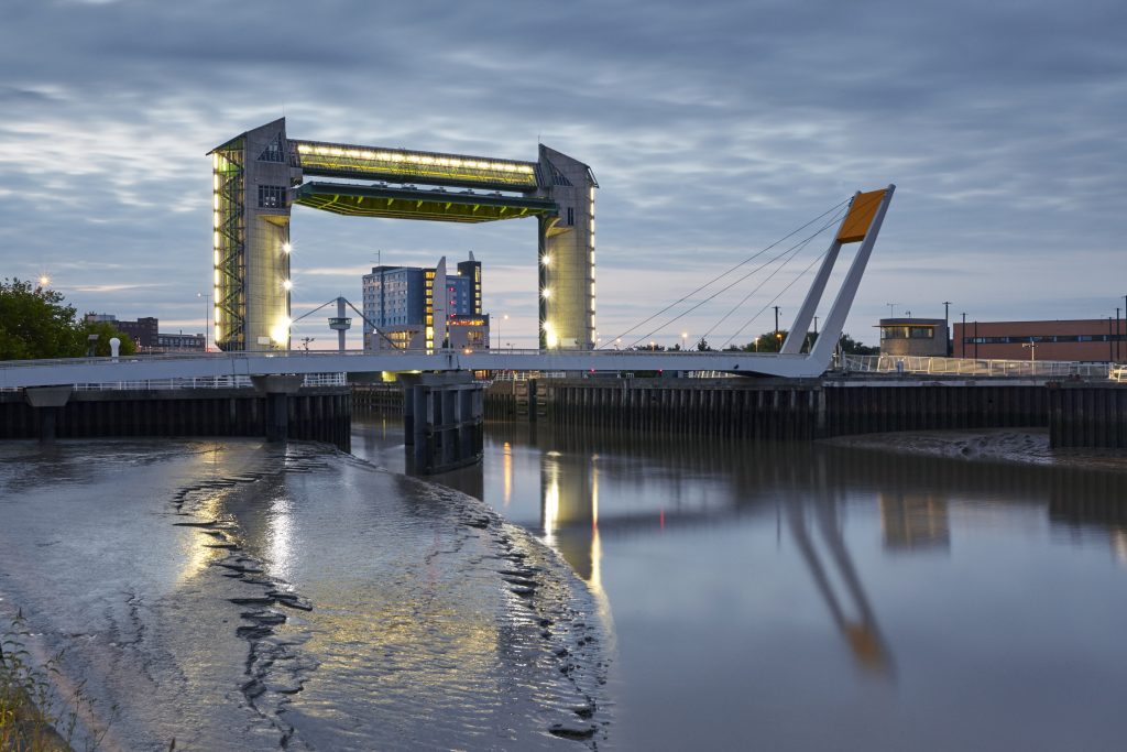 Hull's tidal defence barrier with the river Hull and pedestrian bridge in the foreground